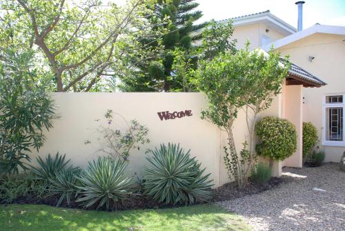 a white wall with the word welcome written on it at Mandalay Guest House Plettenberg Bay in Plettenberg Bay