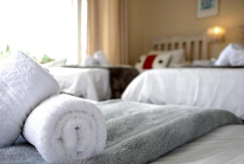 a towel animal sitting on top of a bed at Mandalay Guest House Plettenberg Bay in Plettenberg Bay