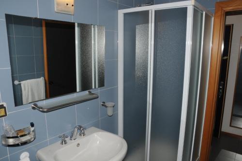a bathroom with a sink and a shower with a mirror at Hotel Eden in Orbassano