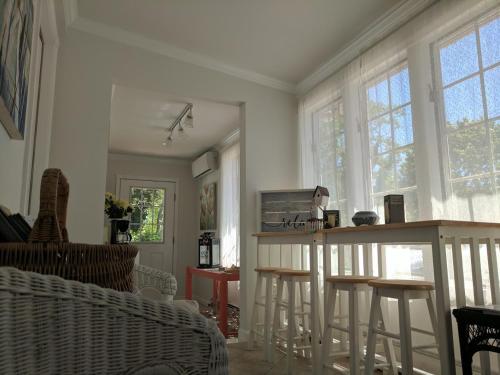 a living room with a table and some windows at Inn At The Park - The Cottage in Cape May