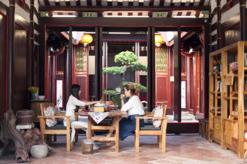 2 personnes assises à une table dans un restaurant dans l'établissement Manju Inn, à Chaozhou
