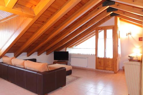 a living room with a couch and a tv at Apartamentos Albá Casa Alquesera in Sahun