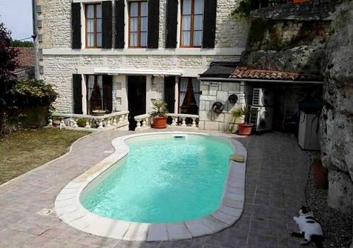 a swimming pool in front of a house at La Maison de l'Aubépin in Saint-Savinien