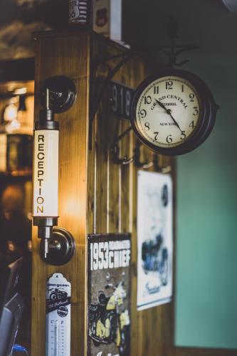 a clock is hanging on a wall with posters at Penzion Rodos - Café in Prague