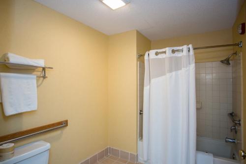 a bathroom with a shower with a white shower curtain at Vagabond Inn Executive in Green Valley