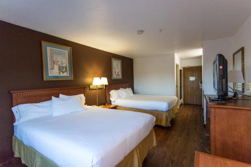 a hotel room with two beds and a television at Vagabond Inn Executive in Green Valley