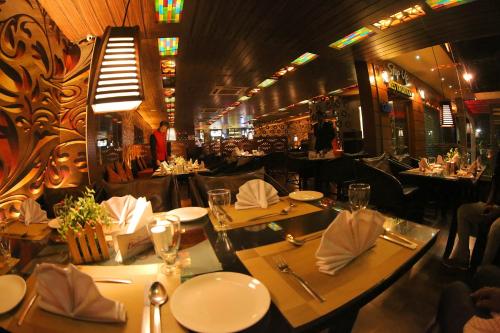 a restaurant with tables set up for a meal at Hotel Hampi International in Hospet