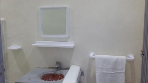 a bathroom with a sink and a mirror at Hôtel familiale les grotte in Aït Ben Haddou
