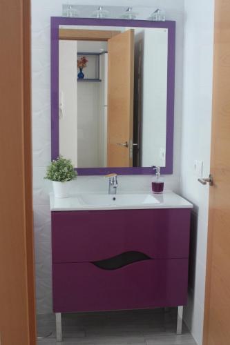 a bathroom with a purple sink and a mirror at Be Happy in Algodonales