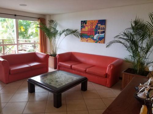 a living room with two red couches and a coffee table at Apart Hotel Beira do Mar in Florianópolis