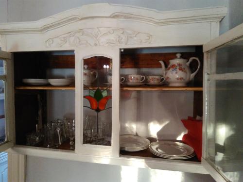 La Dolce Vita في تيغري: خزانة مع الأطباق والأكواب والأطباق فيها