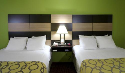 a hotel room with two beds and a table with a lamp at Baymont by Wyndham Sevierville Pigeon Forge in Sevierville