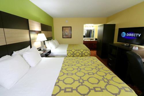 a hotel room with two beds and a flat screen tv at Baymont by Wyndham Sevierville Pigeon Forge in Sevierville