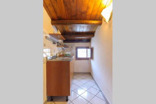 a kitchen with a sink and wooden ceilings at Casa Marcella San Vito Lo Capo in San Vito lo Capo