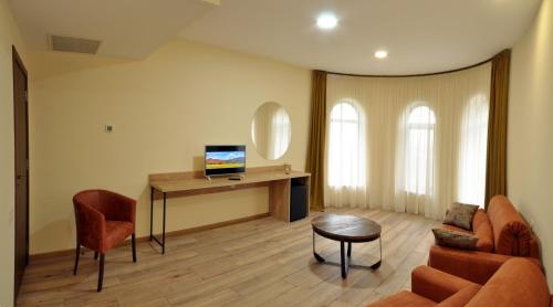 a living room with a couch and a desk with a television at Babaneuris Marani in Babaneuri