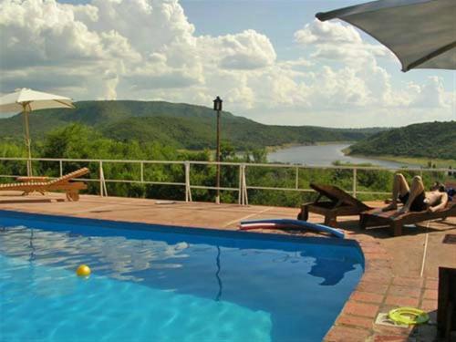 a swimming pool with a view of a river at Apart Mirador del lago- Solo para adultos in Las Rabonas