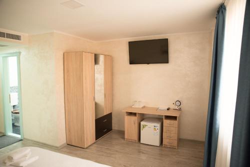 a room with a desk and a television on the wall at La Marcu Pensiune in Tulcea