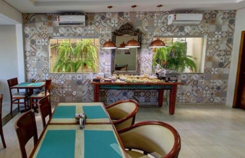 a restaurant with a table and chairs and a mirror at Ecos Conforto in Porto Velho