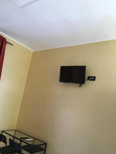 a flat screen tv on the corner of a wall at B & B La Guesthouse in Poirino