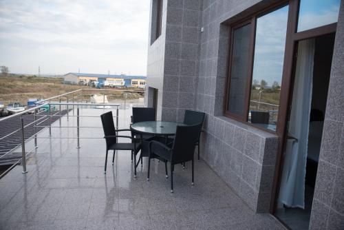 a patio with a table and chairs on a balcony at La Marcu Pensiune in Tulcea