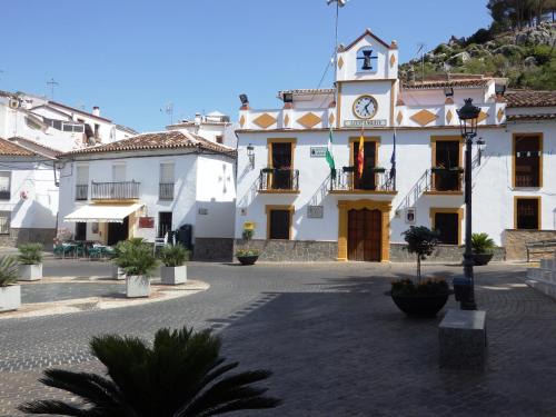 un edificio con una torre de reloj en un patio en Posada del Fresno, en Montejaque