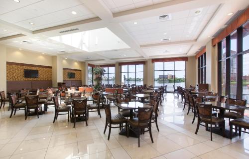 a dining room with tables and chairs and windows at Plaza Suites On International Drive Near Universal Epic in Orlando