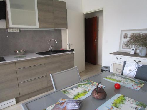 - une cuisine avec une table, 2 chaises et un évier dans l'établissement Residence St PALAIS, à Saint-Palais-sur-Mer