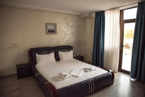 - une chambre avec un lit et 2 serviettes dans l'établissement La Marcu Pensiune, à Tulcea