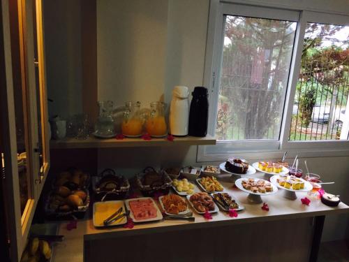 Una mesa con muchos tipos diferentes de comida sobre ella. en Pousada Beija Flor Centro, en Gramado