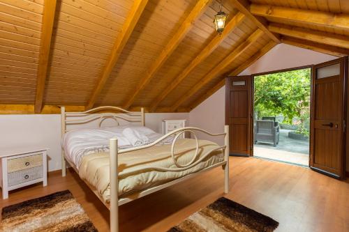 Un dormitorio con una cama y un techo de madera. en Casa do Avo, en Arco da Calheta