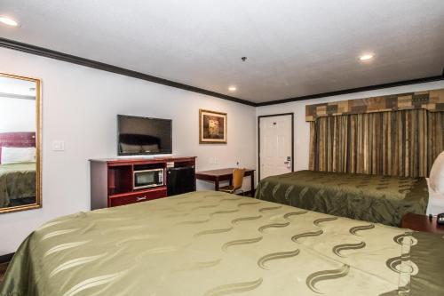 a hotel room with two beds and a television at Americas Best Value Inn Fort Worth in Fort Worth