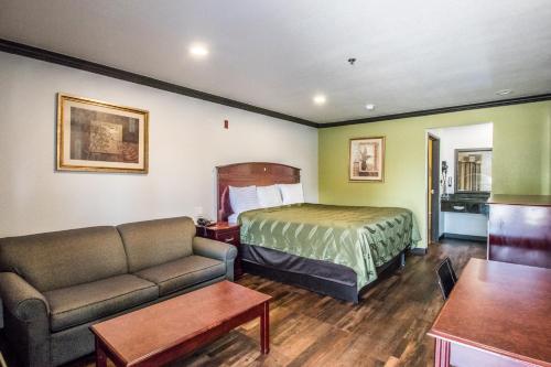 a hotel room with a bed and a couch at Americas Best Value Inn Fort Worth in Fort Worth