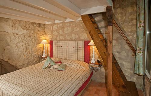 ein Schlafzimmer mit einem Bett in einem Zimmer mit einer Treppe in der Unterkunft Logis Demeure de la Vignole in Turquant
