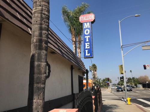 a sign for a restaurant on the side of a building at Stallion Motel Los Angeles in Los Angeles