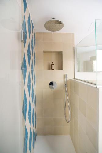a bathroom with a shower with blue and white tiles at Canavall in Palma de Mallorca