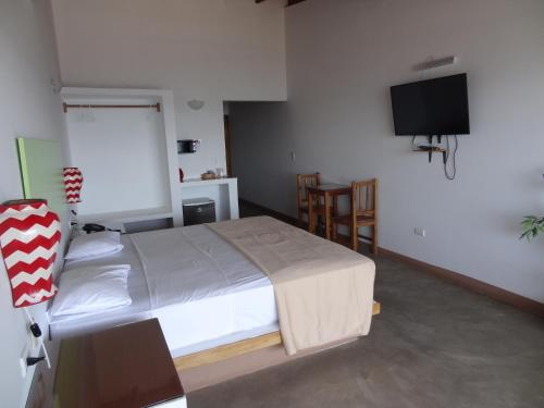 a bedroom with a bed and a flat screen tv at Akas Hotel Apartamentos in Canoas De Punta Sal