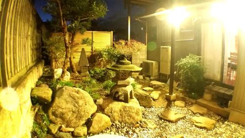 a garden with a statue in the middle of a yard at Tsudoh Stay Hikoso in Kanazawa