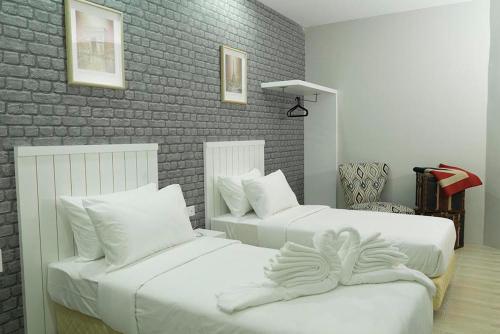 a bedroom with two beds with white sheets at LightHouse Hotel & ShortStay @ Damansara Uptown in Petaling Jaya