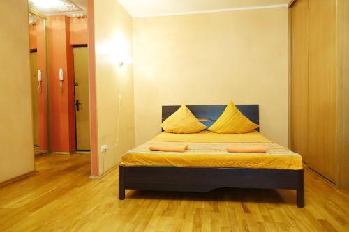 1 dormitorio con 1 cama con sábanas amarillas y almohadas amarillas en Apartments at Volgogradskiy prospekt en Moscú