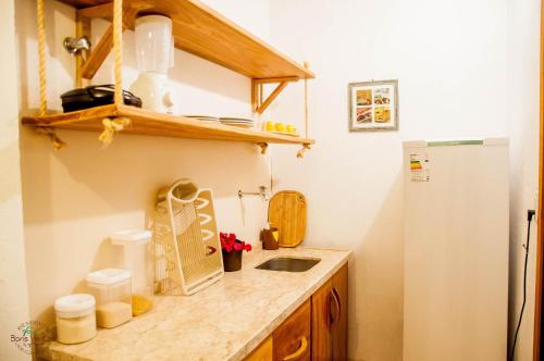 a small kitchen with a sink and a refrigerator at Residence Bons Ventos Jeri in Jericoacoara