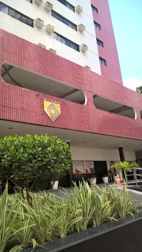 a large red building with plants in front of it at Boa Viagem Flat BVF 777 in Recife