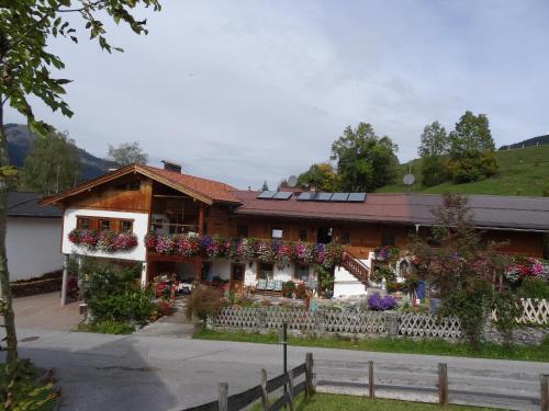 una casa con flores delante en Badhaus en Achenkirch