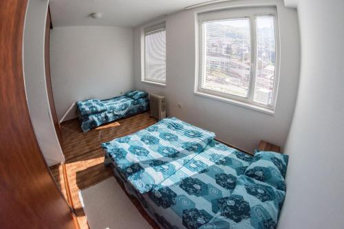a small bedroom with two beds and a window at Apartment Vera in Pluzine