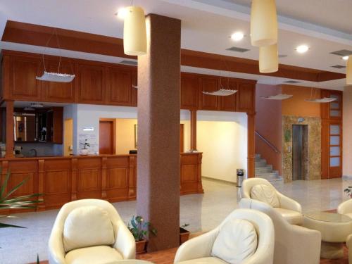 a lobby with white chairs and a pillar at Hotel Millennium in Pogradec