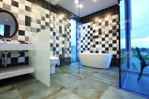 a bathroom with a tub and a sink and a mirror at Hualien S.E.A. B&B in Hualien City