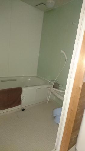 a bathroom with a bath tub and a toilet at Weekly Mansion Ise No.6 in Ise