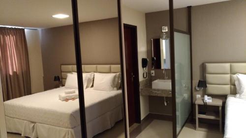 a hotel room with a bed and a mirror at Paracambi Top Hotel in Paracambi