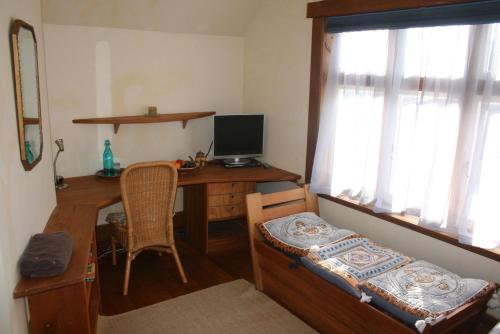 a room with a desk with a computer and a chair at Joya Garden & Villa Studios in Nelson
