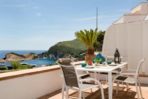 a white table and chairs on a balcony with the ocean at Cap Sa Sal Turquesa in Begur