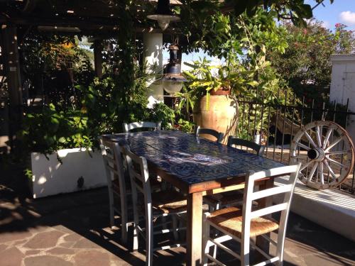 a table and chairs in a patio with plants at La Lampara in Stromboli